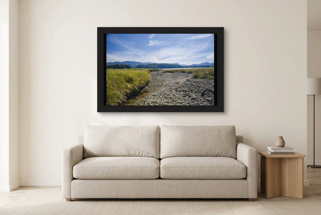 Illustrative room preview of Where the Tide Returns in a black frame above a light sofa. Artwork scale is approximate.