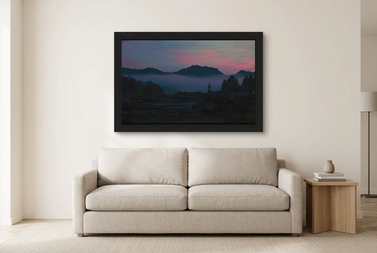 Illustrative room preview of Mountains Beyond the Mist in a black frame above a light sofa. Artwork scale is approximate.