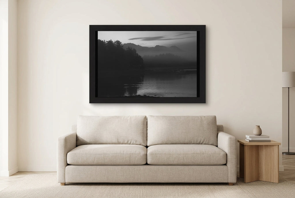 Illustrative room preview of Stillness in Silver in a black frame above a light sofa. Artwork scale is approximate.
